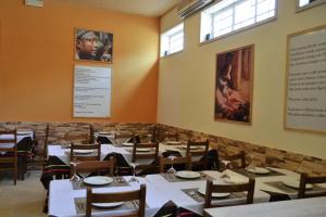 une salle à manger avec des tables et des chaises blanches dans l'établissement Hotel Central, à São Tomé