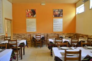 d'une salle à manger avec des tables, des chaises et des murs orange. dans l'établissement Hotel Central, à São Tomé