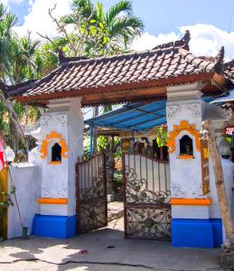 uma pequena casa com um portão e um telhado em Yasa Homestay em Nusa Penida