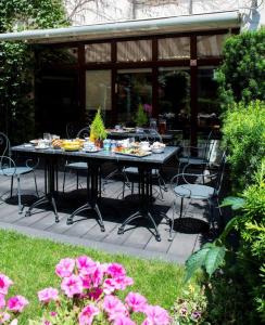 een tafel en stoelen op een patio met roze bloemen bij Parkside Apartments Old Town in Krakau