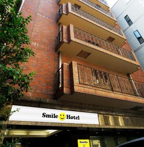 un bâtiment avec un panneau d'hôtel sourire devant lui dans l'établissement Smile Hotel Nihombashi Mitsukoshimae, à Tokyo