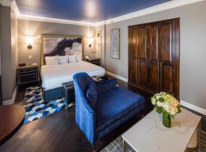 a hotel room with a bed and a blue chair at The Goodwin in Hartford