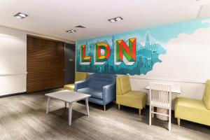 uma sala de espera com cadeiras e um sinal que lê ldn em YHA London Central em Londres