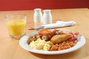 a plate of breakfast food with a glass of orange juice at YHA Bristol in Bristol