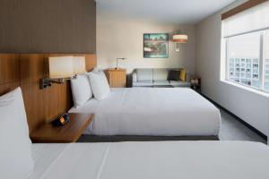 um quarto de hotel com uma cama grande e uma cadeira em Hyatt Place Long Island City em Queens