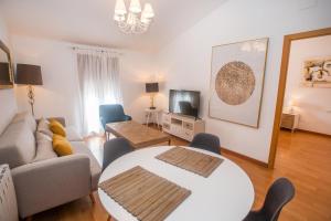 een woonkamer met een bank en een tafel bij Apartamentos Soho Boutique Plaza Mayor Caceres in Cáceres