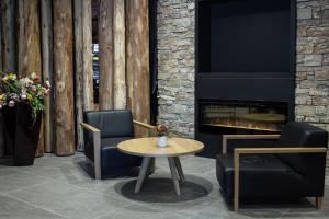 a living room with two chairs and a table and a fireplace at Korona, Resort & Entertainment in Kranjska Gora