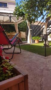 a chair sitting under an umbrella in a yard at Artista B&B in Càbras