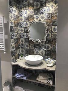 a bathroom with a sink and a mirror on a counter at Dar Corniche La Marsa (Adults Only) in La Marsa