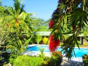 ein Resort mit einem Pool und einigen Bäumen und Blumen in der Unterkunft Tropic Hôtel in Ambondrona