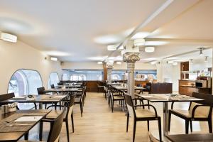 une salle à manger avec des tables et des chaises en bois dans l'établissement Abba Santander, à Santander