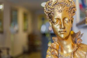 Una statua d'oro di una donna in una stanza di Hotel Vila Tina a Zagabria