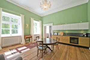 een keuken met een tafel en stoelen in een kamer bij Schloss Retzow Apartments in Retzow