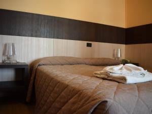 um quarto com uma cama com um cobertor em Hotel Bamby em Rimini