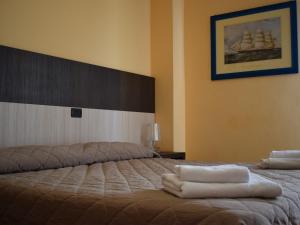 um quarto com uma cama com toalhas em Hotel Bamby em Rimini