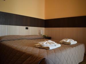 um quarto com uma cama com toalhas em Hotel Bamby em Rimini