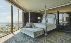 - une chambre avec un lit, une chaise et des fenêtres dans l'établissement Four Seasons Hotel Las Vegas, à Las Vegas