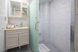 een badkamer met een douche, een wastafel en een toilet bij Chengdu Chenghua·Giant Panda Breeding Base Locals Apartment 00149350 in Chengdu