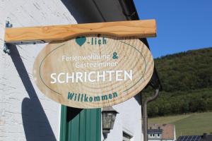 een houten bord aan de zijkant van een gebouw bij Ferienwohnung & Gästezimmer Schrichten in Schmallenberg