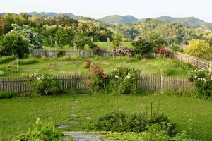 einen Hinterhof mit einem Zaun und einem Garten mit Blumen in der Unterkunft Country House Zunko in Jelovec