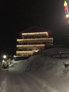 ein Gebäude mit Lichtern im Schnee in der Nacht in der Unterkunft Appartement in 1700m mit Traumblick in Grächen