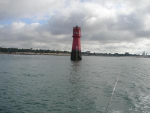 un faro rojo en medio de un cuerpo de agua en T2 Agréable, en Rochefort