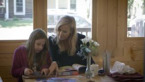 a woman and a girl sitting at a table with a tablet at Elk Mountain Lodge in Crested Butte