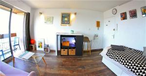 a living room with a couch and a tv at Grand Studio Vue Mer in Douarnenez