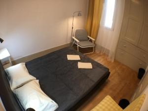 um quarto com uma cama, uma cadeira e uma janela em Stay In Aveiro em Aveiro