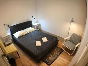 um quarto com uma cama preta e uma cadeira em Stay In Aveiro em Aveiro