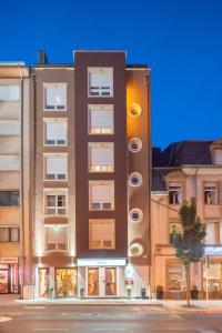 un grand bâtiment sur le côté d'une rue dans l'établissement Best Western Plus Grand Hotel Victor Hugo, à Luxembourg