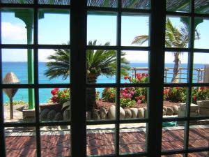 een raam met uitzicht op de oceaan vanuit een resort bij Hotel Casa Del Embajador in Playa Blanca