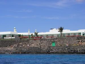 een gebouw bovenop een rotsachtige kustlijn met water bij Hotel Casa Del Embajador in Playa Blanca