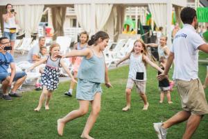 un gruppo di bambini che giocano con un frisbee nell'erba di Holiday Park & Resort Pobierowo a Pobierowo