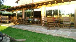 een patio met stoelen, een tafel en ramen bij Posada Herrán in Santillana del Mar