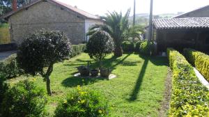 een tuin met bomen en struiken en een gebouw bij Posada Herrán in Santillana del Mar