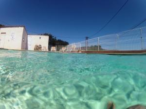 uma piscina de água em frente a uma cerca em Residence La Beloutiere em Porto-Vecchio