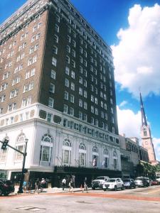 un grande edificio in una strada di città con una chiesa di Francis Marion Hotel a Charleston