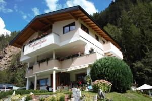 a building in the mountains with flowers on the balcony at Birkenheim Widmann in Längenfeld