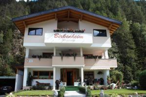 a building with a sign that reads buchwaldicism at Birkenheim Widmann in Längenfeld