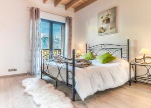 1 dormitorio con cama y ventana grande en Les Edelweiss Mont-Blanc - Gîte Classé 3 Etoiles, en Passy