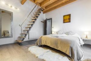 1 dormitorio blanco con 1 cama y escalera en Les Edelweiss Mont-Blanc - Gîte Classé 3 Etoiles, en Passy