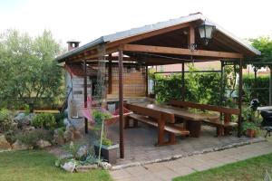 een houten paviljoen met een picknicktafel in een tuin bij Apartment Ivano in Fažana