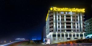 un hotel con un cartel encima de él por la noche en Al Murooj Grand Hotel, en Mascate