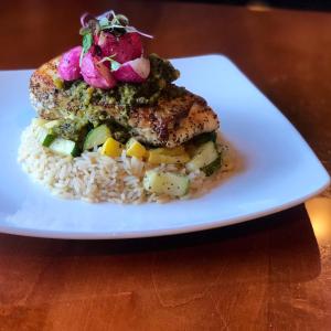 un piatto bianco con un pezzo di pesce e riso di Francis Marion Hotel a Charleston