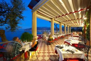 un gruppo di persone seduti ai tavoli su un patio di Hotel Minerva a Sorrento