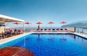 uma piscina com cadeiras e guarda-sóis em Hotel Minerva em Sorrento