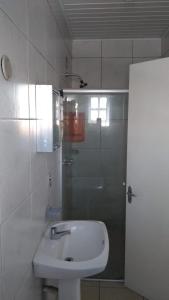 een witte badkamer met een wastafel en een douche bij Ville House Hotel Canoas in Canoas