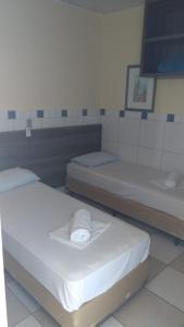 een kamer met 2 bedden en een wastafel bij Ville House Hotel Canoas in Canoas