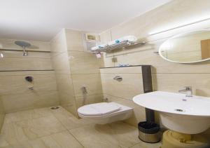 a bathroom with a white toilet and a sink at Hotel iStay in Coimbatore